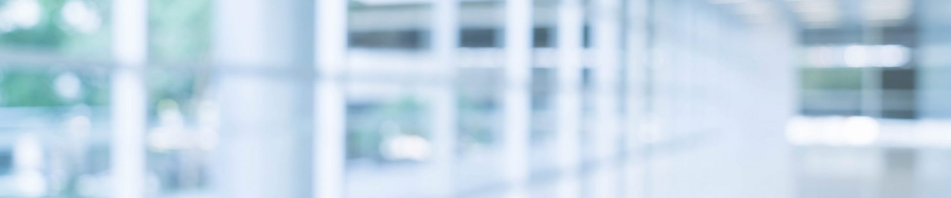 Blurred abstract background interior view looking out toward to Blurred abstract background interior view looking out toward to empty office lobby and entrance doors and glass curtain wall with frame - blue white balance processing style